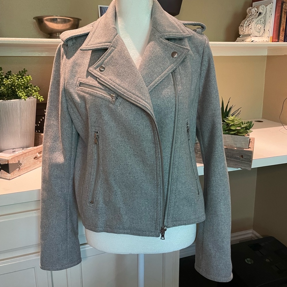 Asymmetrical-zip placket with wide flap with zipper detail on cuff of sleeves.